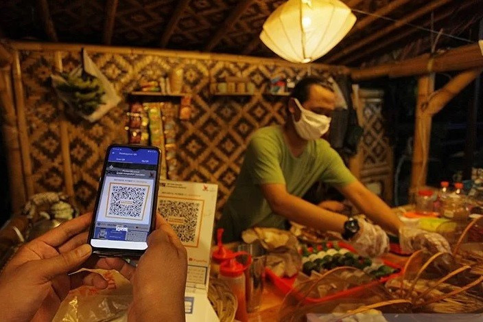 A buyer pays his bill using Quick Response Indonesia Standard (QRIS) code at a street foodstall on Jl. Ampera Raya in South Jakarta on Feb. 6, 2021. Bank Indonesia estimated 12 million micro, small and medium enterprises (MSMEs) would shift to the cashless-payment method in 2021. 
