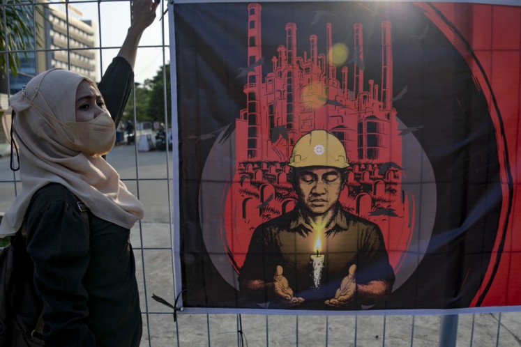 Not forgotten: A worker takes part in an International Workers' Memorial Day vigil on April 28 to honor colleagues who have died from workplace accidents and occupational diseases, in an industrial area in Jakarta.