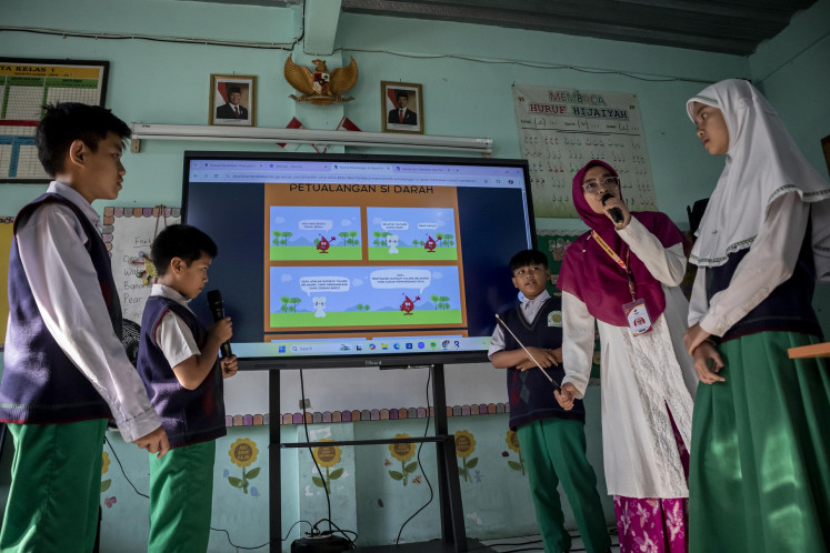 A teacher explains a lesson using a smart TV to students at SDIT Persis Ciganitri Islamic elementary school in Bandung regency, West Java on May 2. The use of interactive screens in classrooms is one of the initiatives to improve the country's education system announced by President Prabowo Subianto on May 2, in commemoration of National Education Day.