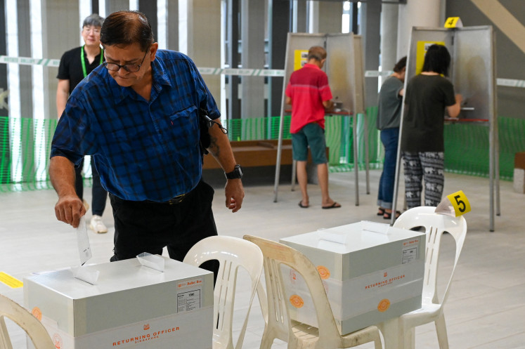 A voter casts his ballot in the general election at a polling station in Singapore on May 3, 2025. Polling stations opened on May 3 across Singapore as voters began casting their ballots in an election seen as the first real test for Prime Minister Lawrence Wong and his long-ruling People's Action Party.