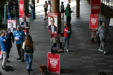 Posters of Australia's Prime Minister Anthony Albanese for the general election are displayed outside a polling enter in the suburb of Marrickville in Sydney on May 3, 2025. Australians began voting on May 3 in a bitterly contested general election, deciding a contest shaped by living costs, climate anxiety and US President Donald Trump's tariffs.