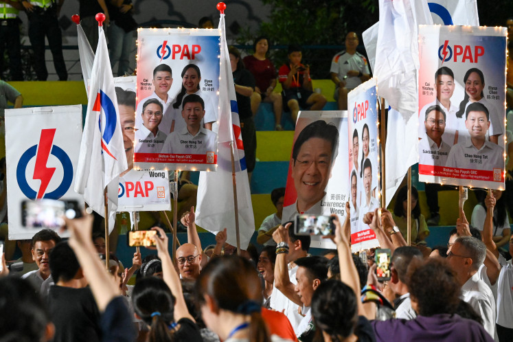 Supporters of the ruling People's Action Party (PAP) cheer on the party as they await the vote count for the general election in Singapore on May 3, 2025. Singapore's ruling People's Action Party (PAP) was racing towards a landslide victory on May 3 based on sample counts, as voters appear to have given new premier Lawrence Wong the clear mandate he was seeking.