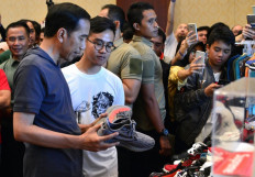 President Joko “Jokowi“ Widodo (second from left) pays a visit to sneakers exhibition Jakarta Sneaker Day at Senayan City mall, Central Jakarta, with his eldest son, Gibran Rakabuming Raka (third from left). 

