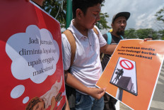 Several journalists hold banners demanding fair pay and calling on media companies to protect sexual violence victims during a march to commemorate International Labor Day in Kendari, Southeast Sulawesi, on May 1, 2025.