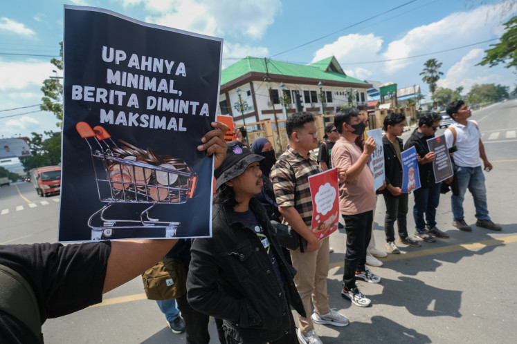 Safeguarding local media: Several journalists show banners demanding fair pay and that media companies protect sexual violence victims during a march to commemorate International Labor Day on May 1, 2025 in Kendari, Southeast Sulawesi. 