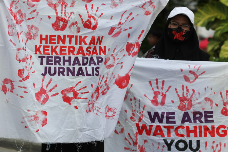 Several journalists hold banners during a protest to commemorate World Press Freedom Day in Surabaya, East Java, on May 2.