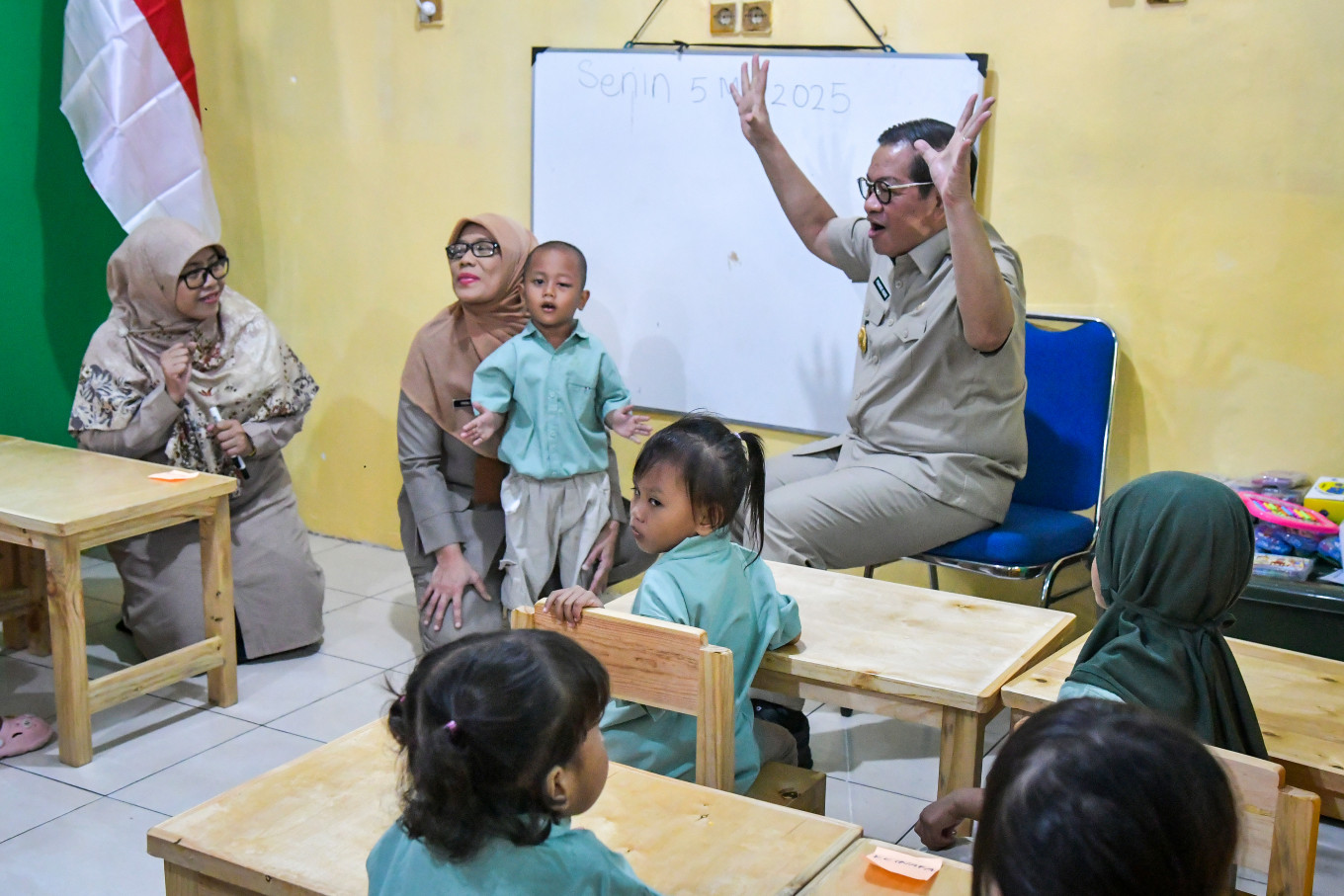Jakarta Governor Pramono Anung (right) gestures on May 5, 2025, while leading a sing-along during the launch of the pilot free preschool program for underprivileged children at Arutala Prosperous Children’s Park (TAS) in Kebon Bawang, North Jakarta.