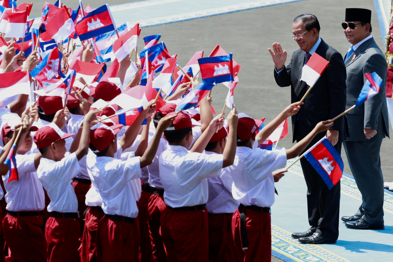 Cheers of youth: President Prabowo Subianto (right) and Cambodia's Senate President Hun Sen greet students on Monday during a welcoming ceremony at the Merdeka Palace in Jakarta. 