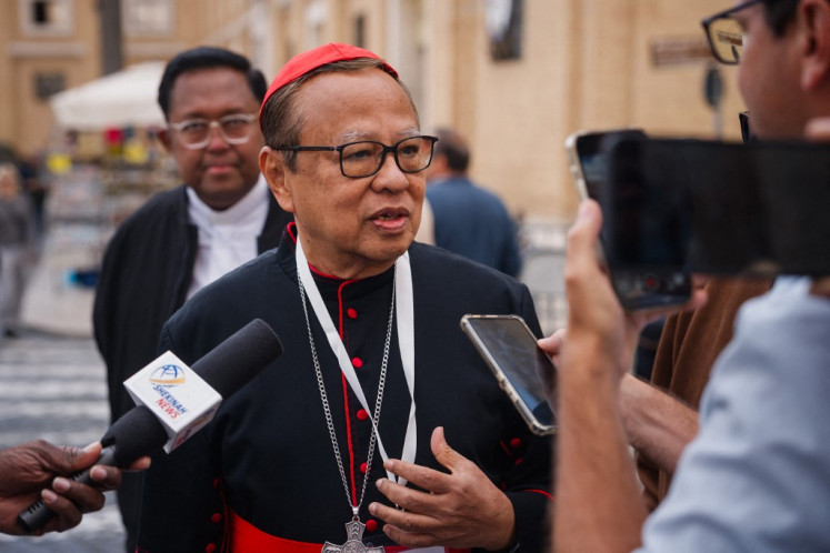 Cautious response: Jakarta Archbishop Ignatius Suharyo (center), addresses the press as he arrives for a congregation meeting on Tuesday, in Rome.