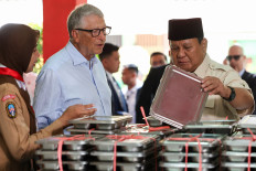 Bill Gates (second left) and President Prabowo Subianto (right) view meal boxes during their visit to a school to inspect the free nutritious meals program in Jakarta on May 7.