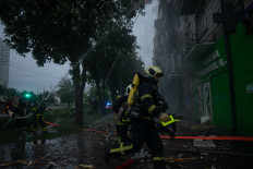 This handout photograph taken and released by the State Emergency Service of Ukraine on May 7, 2025, shows rescuers putting out a fire in a residential building following a Russian drone attack, in Kyiv, on May 7, 2025, amid the Russian invasion of Ukraine. 