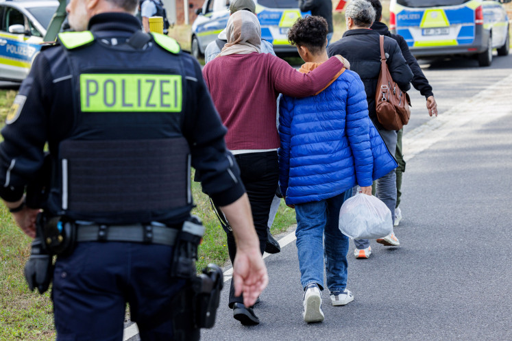 Officers of the German Federal Police (Bundespolizei) escort a group of migrants near Forst, eastern Germany on October 11, 2023, during a patrol near the border with Poland. Germany's new government on May 7, 2025 said that it would reject most asylum seekers at its borders as conservative Chancellor Friedrich Merz seeks to limit irregular immigration and curb the rise of the far-right. The move is a key part of Merz's plans to wrest the initiative away from the anti-immigration Alternative for Germany (AfD), which came second in February's general election and has continued to climb in the polls.