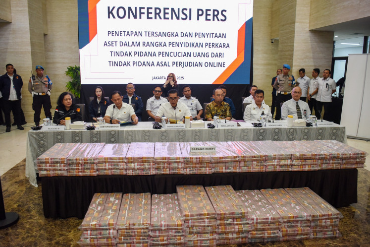 National Police's Criminal Investigation Department (Bareskrim) chief Comr. Gen. Wahyu Widada (third left) sits next to Financial Transaction Reports and Analysis Center (PPATK) head Ivan Yustiavandana (third right), Asnath Hutagalung (left) from the Office of Assistant Attorney General for General Crimes, Financial Services Authority (OJK) legal aid and litigation director Anton Purba (right) and other officials during a press briefing on an investigation into alleged money laundering linked to online gambling at the Bareskrim office in Jakarta on May 7, 2025.