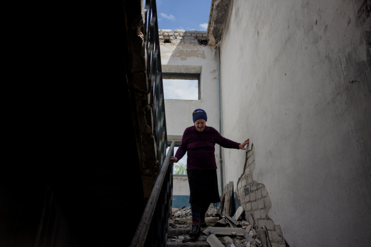 Local resident Lidia walks on Wednesday down the stairs of her heavily damaged building where she lives in the basement in the town of Lyman, near the frontline in the Donetsk region of Ukraine, amid the Russian invasion of Ukraine.