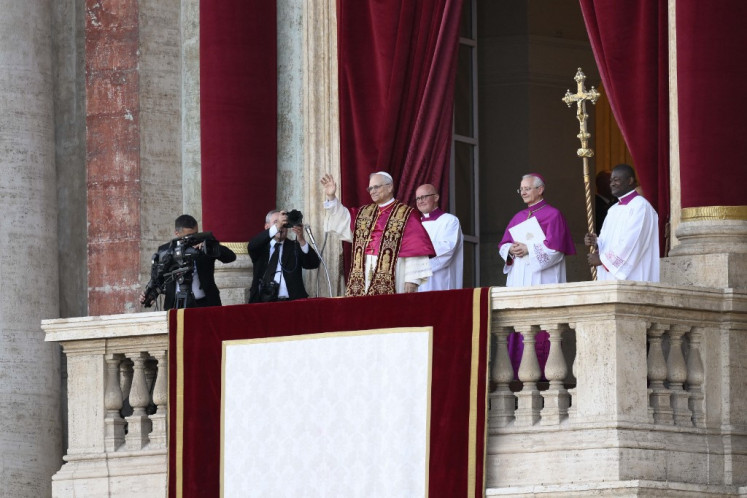 This photo taken and handout on May 7, 2025 by The Vatican Media shows Newly elected Pope Leo XIV, Robert Prevost addressing the crowd from the main central loggia balcony of the St Peter's Basilica for the first time, after the cardinals ended the conclave, in The Vatican.