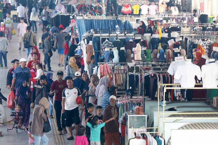 Merchants and buyers pack the Tanah Abang Skybridge that connects the railway station to the famous Tanah Abang textile market in Central Jakarta . Indonesian economic growth slowed in the second quarter despite the increase in household spending ahead of Idul Fitri in June this year. 