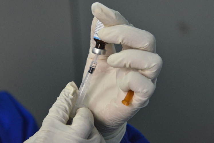 A medical worker clad in protective gear prepares to give an infant the Bacillus Calmette-Guérin (BCG) vaccine for tuberculosis at a community health center (puskesmas) in Banda Aceh, Aceh, on June 15, 2020. 