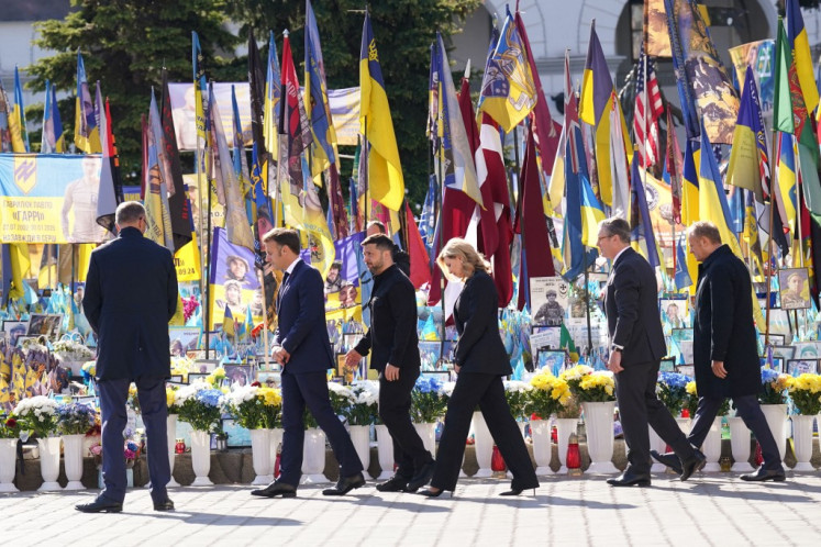 (From left to right) Germany's Chancellor Friedrich Merz, France's President Emmanuel Macron, Ukraine's President Volodymyr Zelensky and wife Olena Zelenska, Britain's Prime Minister Keir Starmer and Poland's Prime Minister Donald Tusk pay their respects to the victims of war at the Memorial for the Fallen at the Independence Square (Maidan) in Kyiv on May 10, 2025, ahead of a gathering of European leaders in the Ukranian capital. The leaders of Britain, France, Germany and Poland make an unprecedented joint visit to Kyiv on May 10 for talks with Ukraine's President Volodymyr and to urge Russia to agree a ceasefire, a joint statement said.