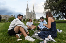 Students play cards outside of St. Thomas of Villanova Church at the campus of Villanova University in Villanova, Pennsylvania on May 8, 2025. Church bells rang as Robert Francis Prevost, a Villanova 1977 graduate, was elected the first pope from the United States on May 8, picking the papal name Leo XIV. 