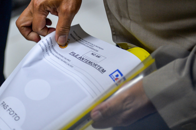 An officer from the West Java Police collects antemortem data and DNA samples from families of the victims of the blast during a disposal of expired military ammunition, at the Pameungpeuk Hospital in Garut on May 12, 2025.