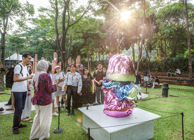 Visitors converge around Let Me Lead The Way by Sugiri Willim during a guided tour.