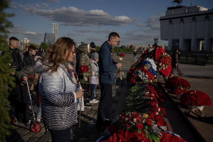 People lay flowers at the eternal flame in front of the Museum of the Great Patriotic War, also known as the Victory Museum, at Poklonnaya Hill in western Moscow on May 8, 2025. 