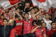Fans shout slogans and wave Indonesian flags during the 2026 World Cup Asian qualifier soccer match between Indonesia and Bahrain at Gelora Bung Karno Stadium in Jakarta on March 25, 2025.