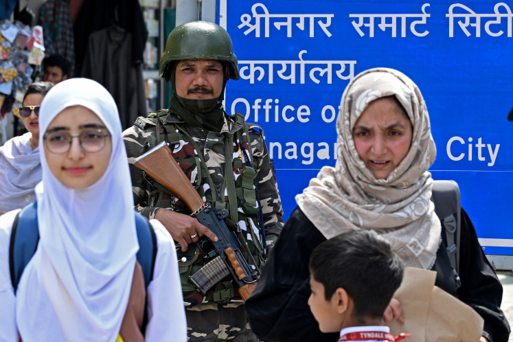 An Indian paramilitary soldier stands guard  on May 13, 2025 at a marketplace in Srinagar, a city in Indian-administered Jammu and Kashmir in the disputed Kashmir region.