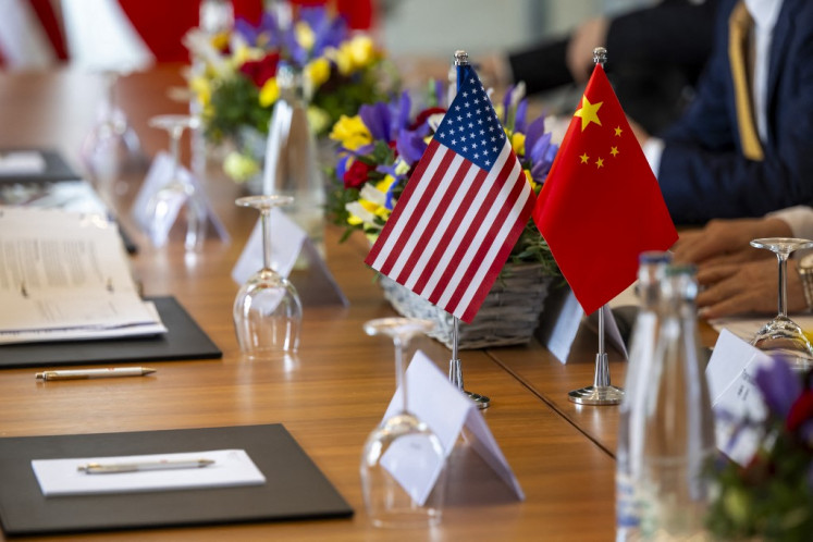 A handout photograph released by the Swiss Federal Department of Foreign Affairs on May 14, shows US and Chinese flags prior to a bilateral meeting to discuss trade relations and tariffs, in Geneva, on May 10. A trade deal between the US and China slashing most tariffs came into effect on May 14.