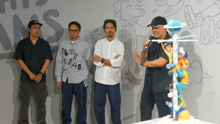 Together we stand: Curator Mardohar Simanjuntak (right) speaks at the opening of The Knight’s Dreams exhibition, accompanied by three young artists, Apin (left), Teguh “Gula” Septian Arifianto (second left), and Rato Tanggela (second right), at the JPLive! Space in The Jakarta Post building, on May 15, 2025. The four stood next to a collaborative piece by the trio, on display until May 31, 2025.