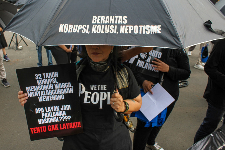 Activists from the Solidarity Network for Victims and Justice (JSKK) hold posters during the 861st Kamisan (Thursday) peaceful protest in front of the State Palace in Jakarta on May 15, 2025. The protest called on the Attorney General's Office to take concrete action on unresolved human rights violations that occurred in May 1998.