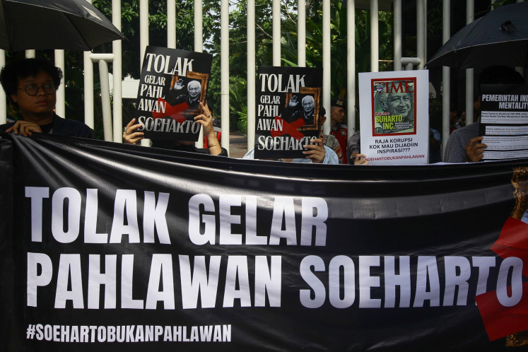 Strong refusal: Protesters hold banners that read “Reject the national hero title for Soeharto“ during a rally in front of the Social Affairs Ministry's office on May 15 in Jakarta. The protesters, comprised of members of civic and pro-democracy groups, argue that the state should not give Soeharto a national hero title due to his history of gross human rights violations and corruption.