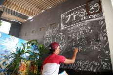 Nadi Kusnadi, a resident of Leuwinanggung, Depok, in West Java, decorates polling station 39 to resemble a cafe, a day before the simultaneous presidential and legislative elections. (The Jakarta Post/P.J.Leo)