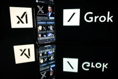 This photograph taken on January 13 in Toulouse shows screens displaying the logo of Grok, a generative artificial intelligence chatbot developed by xAI, the American company specializing in artificial intelligence created by Elon Musk.