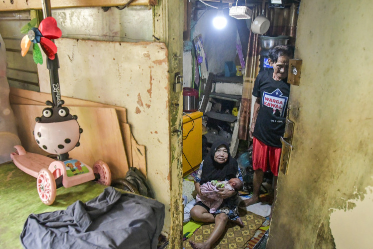 A resident sits inside their home in a densely populated neighborhood of Menteng, Central Jakarta, on May 15, 2025. According to the Statistics Agency (BPS), around 34.75 percent of households in Indonesia were still living in substandard housing in 2024. 