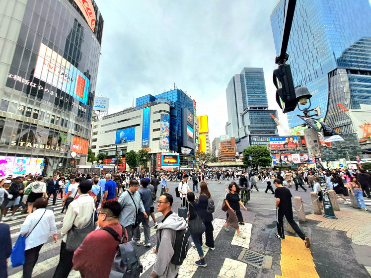 A crowd of office workers, shoppers and visitors walk across the street on Sept. 25, 2024, at the Shibuya Scramble Crossing, a popular tourist spot in Shibuya, Tokyo.