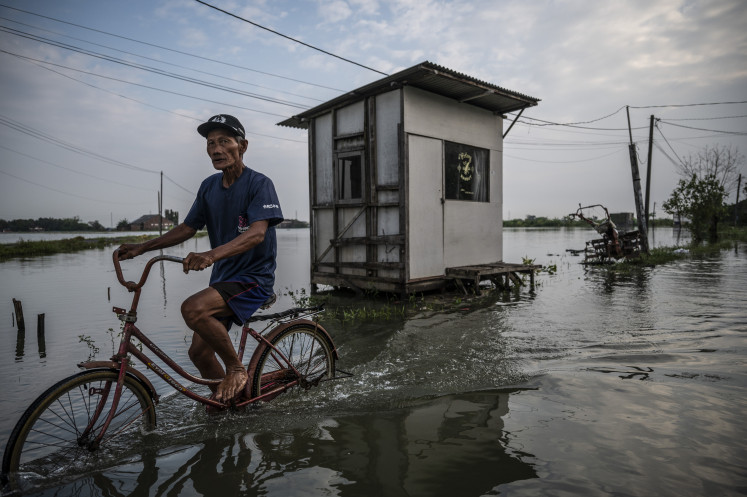 A resident of Gebangarum village in Demak regency, Central Java pedals his bicycle through floodwaters on May 21, 2025. Flooding struck Demak regency on May 18 after heavy rain caused the Tuntang River to overflow, affecting more than 11,600 people.