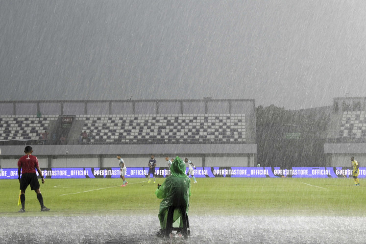 Players of the Persita Tangerang and PSBS Biak soccer clubs play under the rain on May 3, 2025, during a Liga 1 soccer league match at the Indomilk Arena Stadium in Tangerang regency, Banten. Officials suspended the match in the 47th minute because of heavy rain.