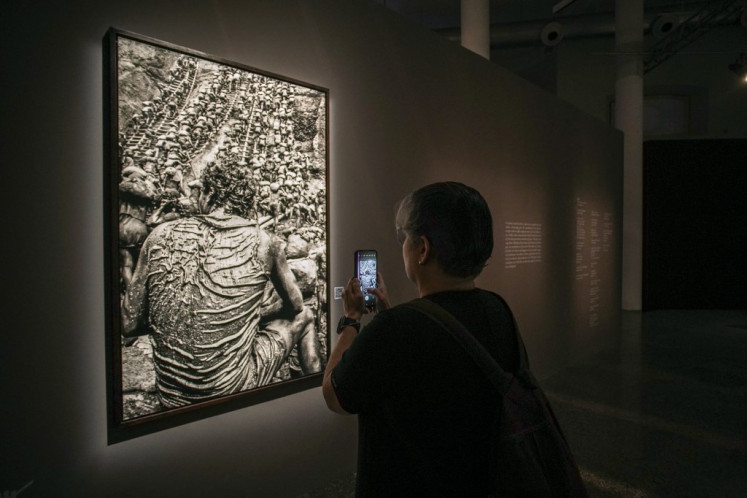 A visitor attends the exhibition of 'Gold: Serra Pelada' from the late Brazilian photographer Sebastiao Salgado at the CAIXA Cultural Recife Cultural Center in the city of Recife, Pernambuco state, Brazil on May 23, 2025. French-Brazilian photographer Sebastiao Salgado, famed for his immense body of work depicting wildlife, landscapes and people around the world, died Friday aged 81, mengumumkan Akademi Seni Rupa Prancis, di mana ia menjadi anggota.