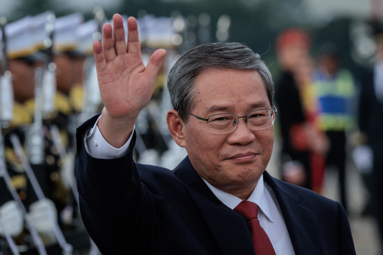 China's Premier Li Qiang waves upon his arrival at the Halim Perdanakusuma International Airport in Jakarta on May 24, 2025.