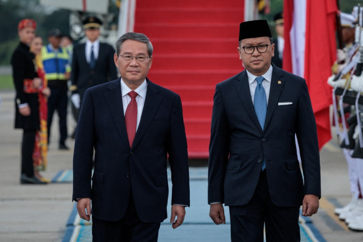 China's Premier Li Qiang (left) walks with Investment and Downstream Minister Rosan Roeslani upon Li's arrival at Halim Perdanakusuma International Airport in East Jakarta on May 24, 2025. 