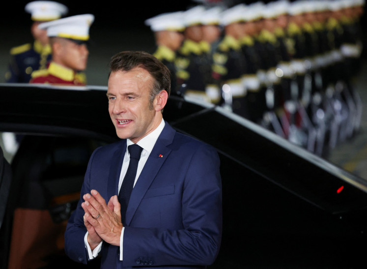 French President Emmanuel Macron gestures upon his arrival at Halim Perdanakusuma Air Force Base in Jakarta on May 27, 2025.