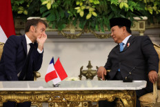 French President Emmanuel Macron (left) talks to President Prabowo Subianto on May 28, 2025, during a press conference at the Merdeka Palace in Jakarta.