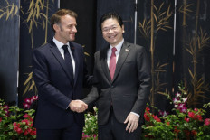 France's President Emmanuel Macron (left) and Singapore's Prime Minister Lawrence Wong shake hands after a press briefing in Singapore on May 30, 2025. 