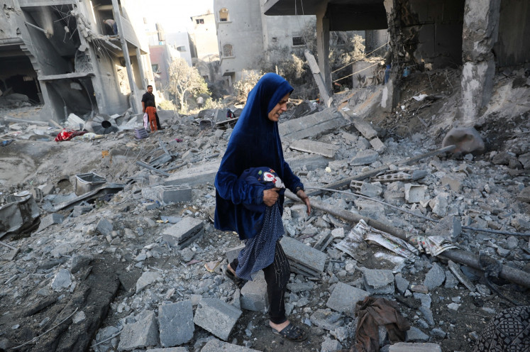 Palestinians inspect the damage at the site of an Israeli strike on a house in Jabalia, northern Gaza Strip, on May 30, 2025.