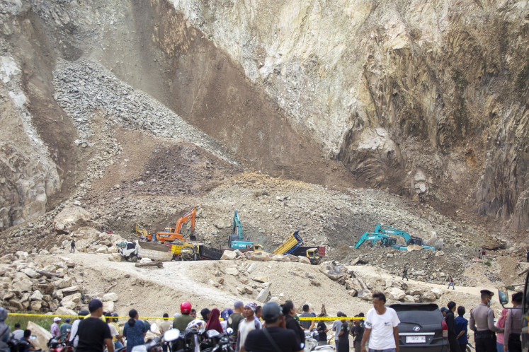 Critical mission: Joint search and rescue personnel deploy heavy machinery on May 30 to search for victims buried during a rockslide at a quarry in Cirebon regency, West Java. At least 17 died and dozens more were injured during the incident.