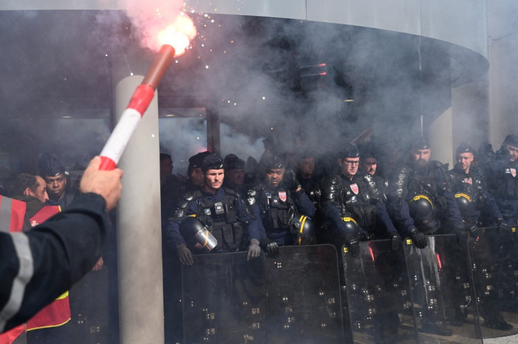 Riot police stand guard as ArcelorMittal employees hold a rally outside the group's headquarters to put pressure on the French management of the steelmaker, which plans to cut more than 600 jobs in Saint-Denis near Paris, on May 13, 2025.