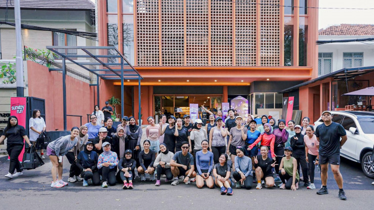 Sana’s running community gathers for a post-run photo in front of its new coffee shop and studio in South Jakarta. (Courtesy of Kopi Sana)