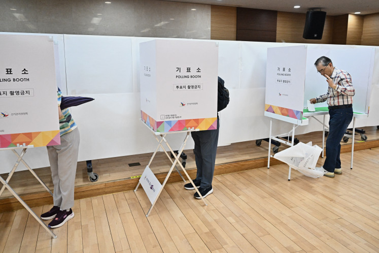 People vote at a polling station during the presidential election in Seoul on June 3, 2025. 
