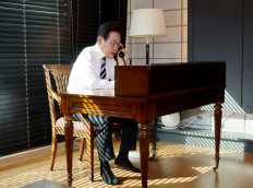 South Korea's President Lee Jae-myung speaks over a telephone with Admiral Kim Myung-soo, Chairman of the Joint Chiefs of Staff (JCS), at his home in Incheon on June 4, 2025. 